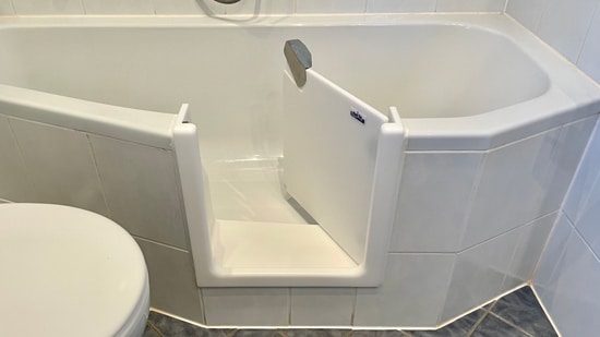 Badewannentür in einer weißen Eckbadewanne
